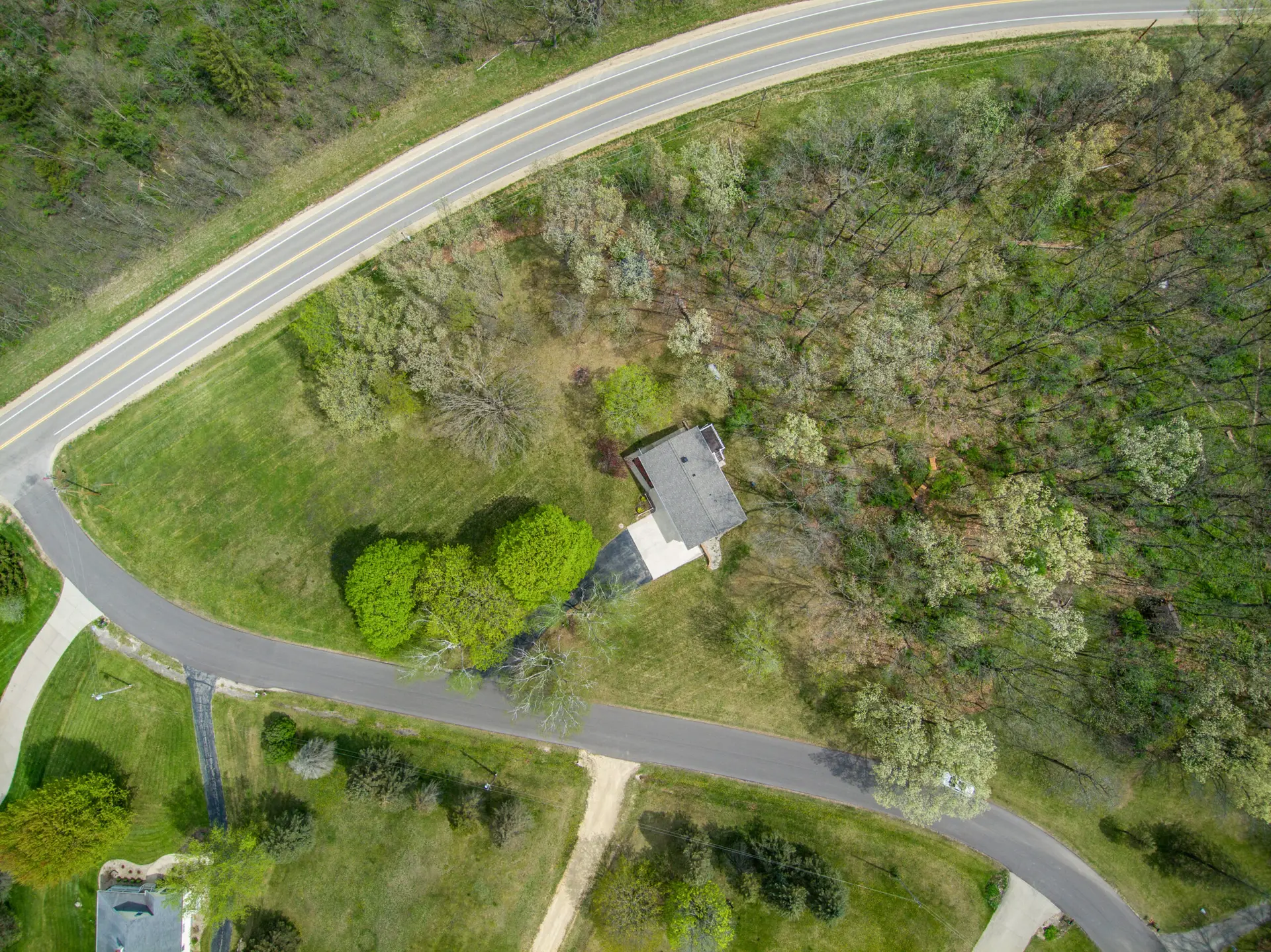 Birds eye view of 1.3 acre lot with woods surrounding home and front open yard